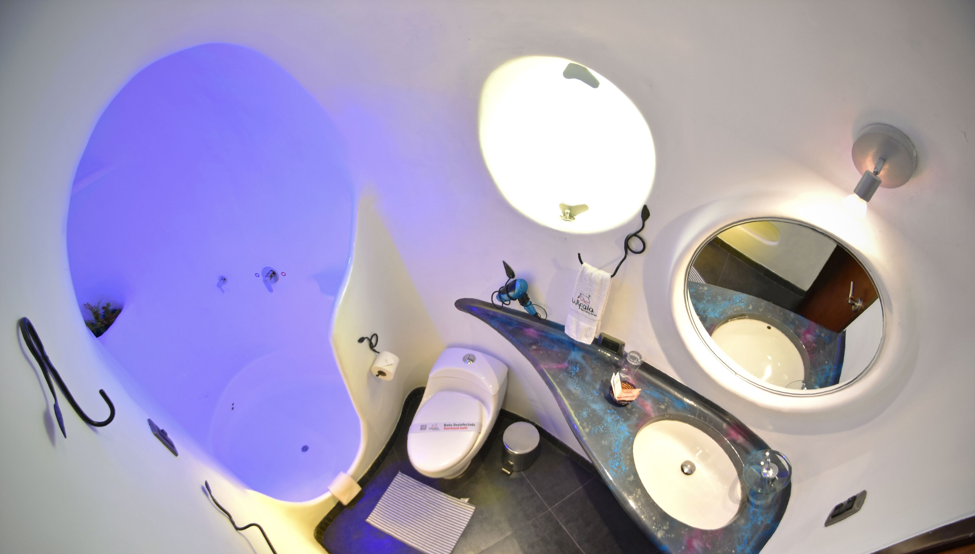Een badkamer met een groot bad, toilet en een wastafel met spiegel.