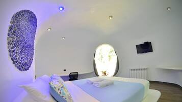 Una camera da letto moderna con un letto, una grande finestra, una TV a schermo piatto e un'opera d'arte unica al muro.