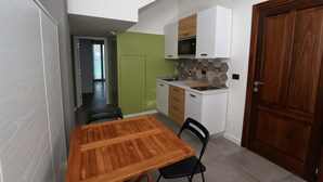 A compact kitchen with a wooden table and chairs, a microwave, and a sink. - b & b in the historic center, with a panoramic terrace, 400 meters from the sea (Pizzo)