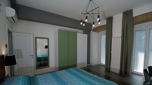 A modern bedroom with a large bed, a green wardrobe, a mirror, and a ceiling light fixture. - b & b in the historic center, with a panoramic terrace, 400 meters from the sea (Pizzo)
