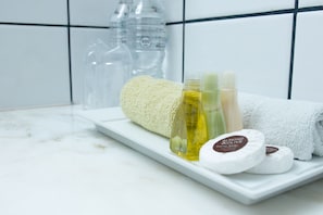 Una encimera de baño con una toalla blanca, una botella de loción y dos pastillas de jabón.