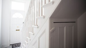 En vit trappa på insidan av huset, med en dörr längst upp.