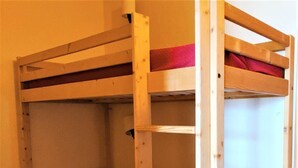 Una cama litera con colchón rojo y estructura de madera.