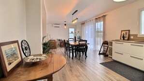 Une cuisine moderne avec des meubles blancs et une table à manger en bois.