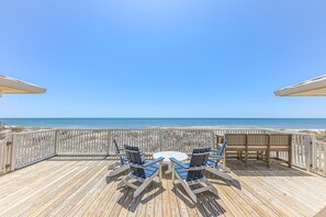 A wooden deck with a round table and four chairs, overlooking a beach. - Gorgeous Beachfront Home! Panoramic Ocean Views. Private walkway to the beach. (Gulf Shores)