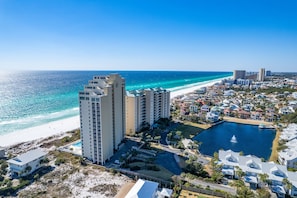 A coastal resort area with high-rise buildings, a beach, and a large body of water.