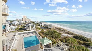 A resort with a pool, beach access, and a view of the ocean.