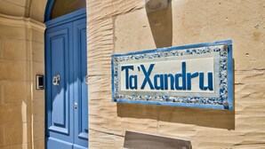 A blue door with a sign above it that reads "Ta Xandru".