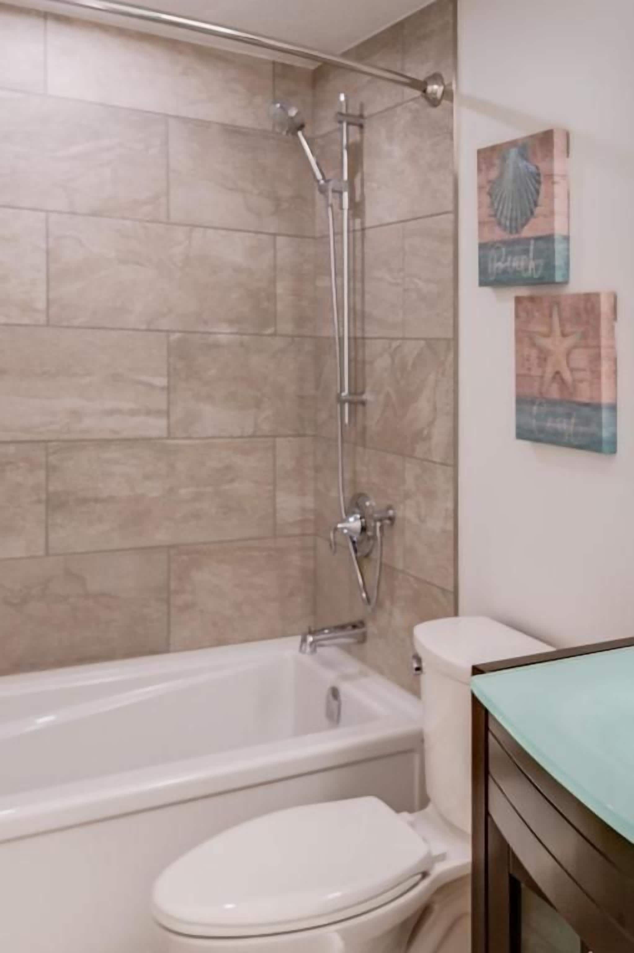 A bathroom with a bathtub, toilet, and shower.