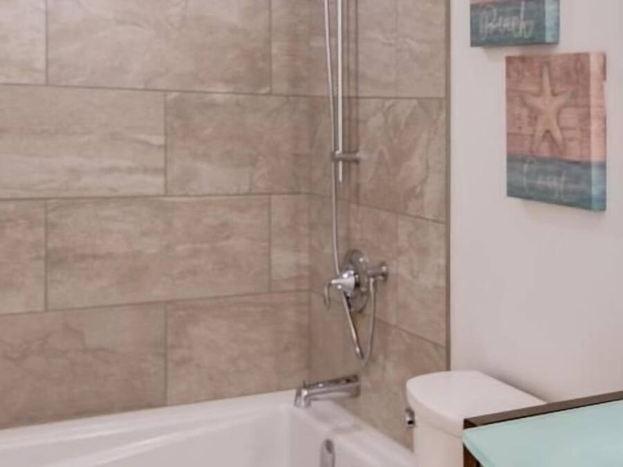 A bathroom with a bathtub, toilet, and shower.