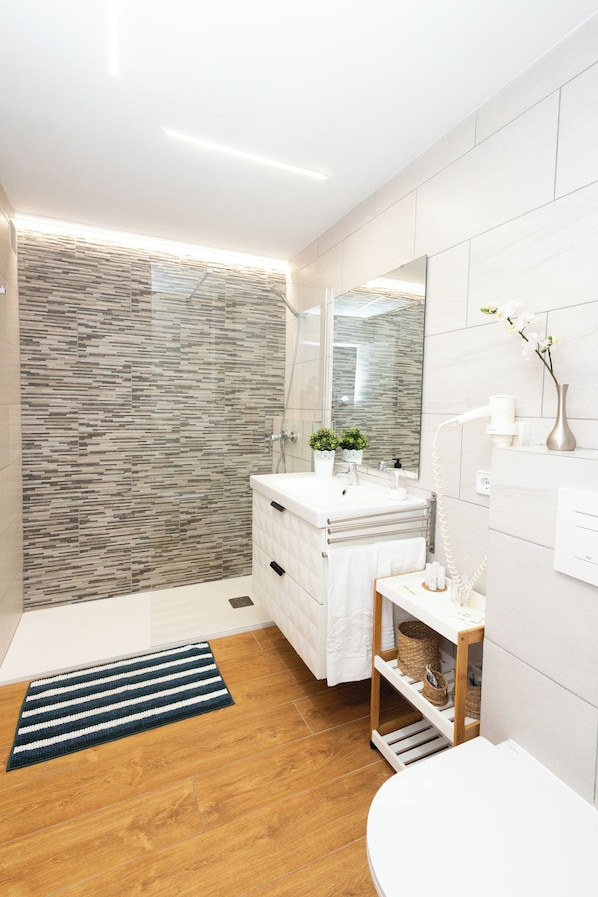 Bathtub, hair dryer, towels, toilet paper