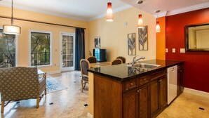A spacious kitchen with a large island, wooden cabinets, and a red accent wall. - Gorgeous condo, super comfy, with view of the pool in Lake Las Vegas Village. (Henderson)