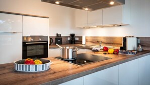 Een moderne keuken met roestvrijstalen apparatuur, een houten aanrechtblad en een ingebouwde kookplaat.