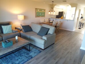 Relax in this stylish living room with a sofa, coffee table, and dining area.