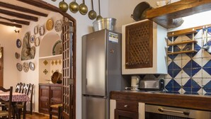 Uma cozinha com geladeira de aço inoxidável, armários de madeira e painel de azulejos.