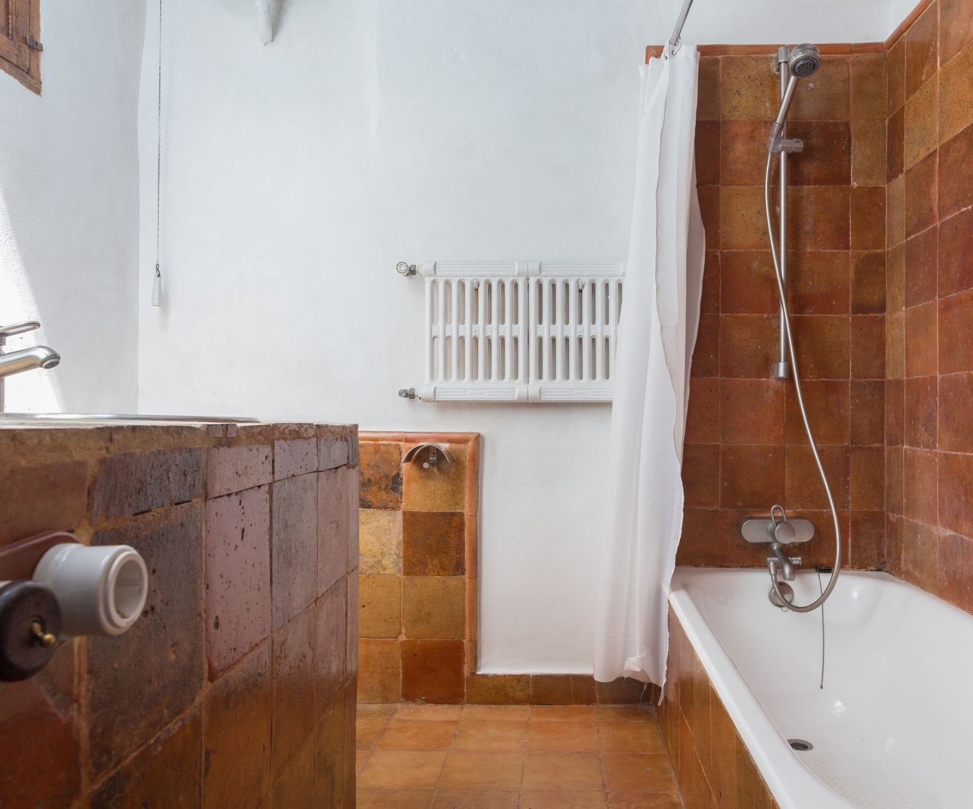Ein Badezimmer mit Badewanne, Dusche und einem weißen Handtuchwärmer.