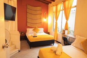 A hotel room with a bed, a desk, a chair, a TV, and a window with curtains. - Africa house-Casa Hotel Laureles-La70 (Medellín)