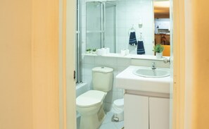 A bathroom with a toilet, sink, and mirror. - Africa house-Casa Hotel Laureles-La70 (Medellín)