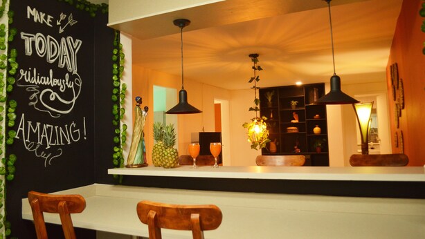 A kitchen with a chalkboard wall, wooden chairs, and pendant lighting. - Africa house-Casa Hotel Laureles-La70 (Medellín)