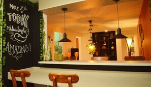A kitchen with a chalkboard wall, wooden chairs, and pendant lighting. - Africa house-Casa Hotel Laureles-La70 (Medellín)