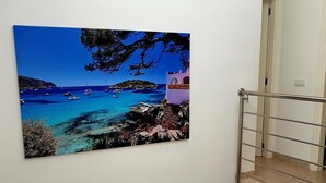 A staircase with a railing, a painting of a coastal scene, and a door in the background. - Luxurious villa near beach: swimming pool (heatable), whirlpool, high speed WiFi (Cala Murada)