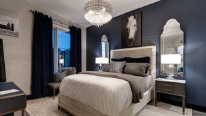 A bedroom with a large bed, a chandelier, a mirror, and a painting on the wall. - Downtown Exquisite Couples Weekend Getaway+Parking (Nashville)