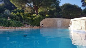 A clear blue pool with a stone wall and a statue in the background. - Superb Villa on the heights of Bellegarde (Gard) (Bellegarde)