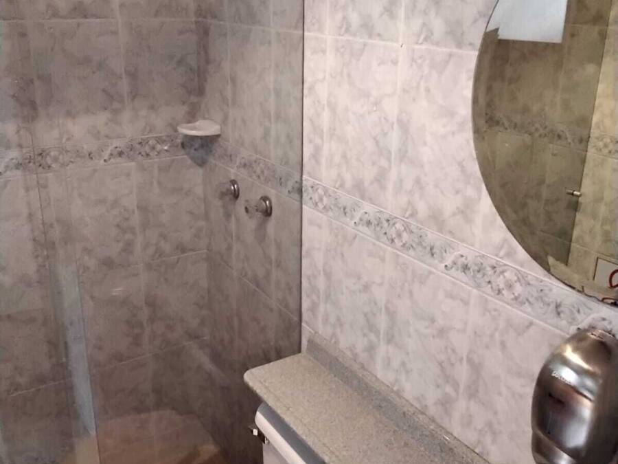 Un bany amb dutxa, vàter, banyera i mirall.