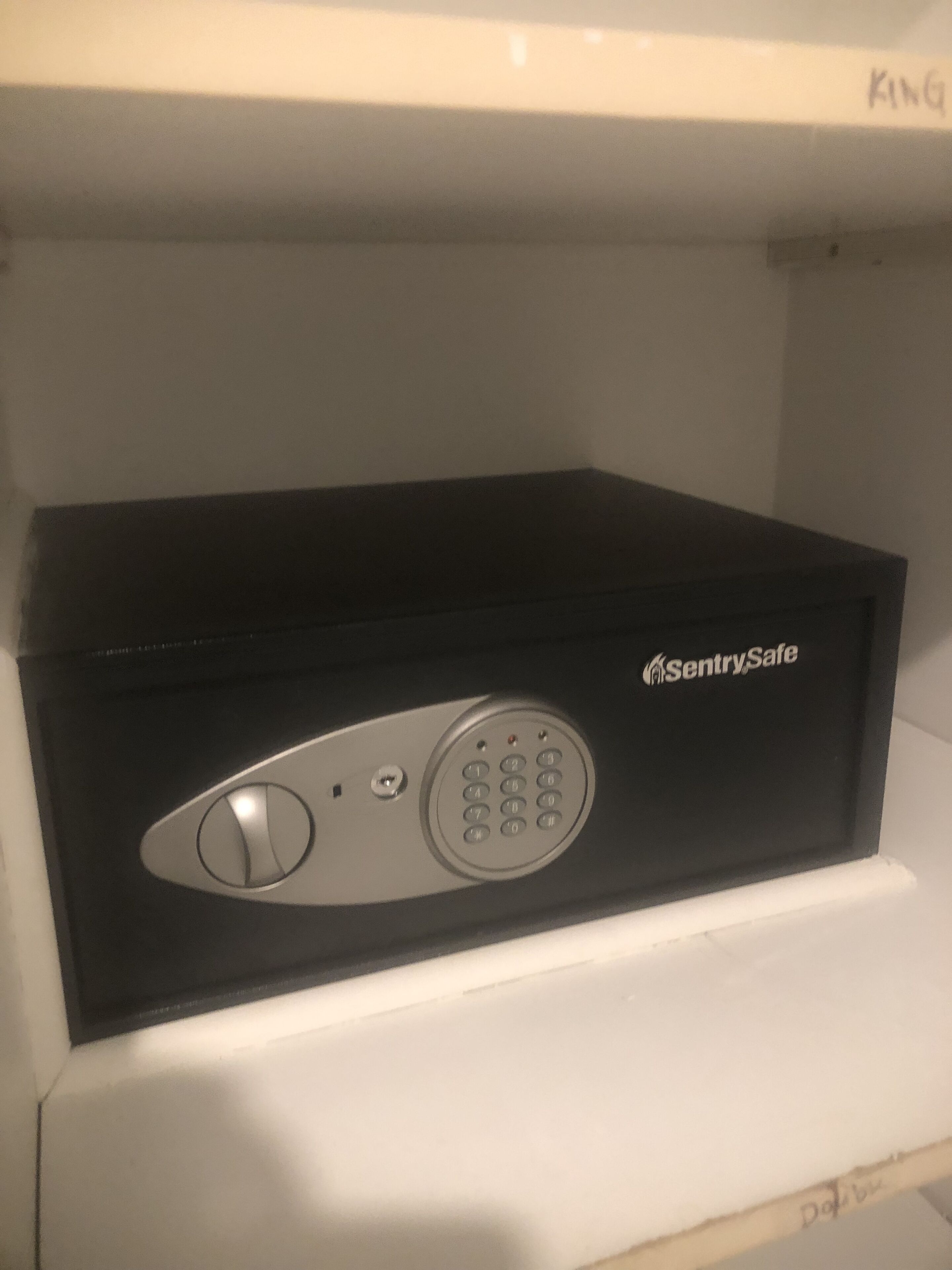 A black box-shaped device with a keypad and a small button, labeled "SentrySafe."