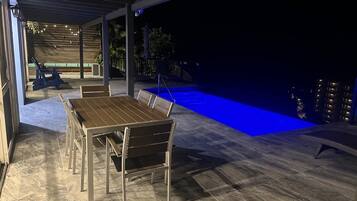 Een buitenzwembad, een verwarmd zwembad, ligstoelen bij het zwembad