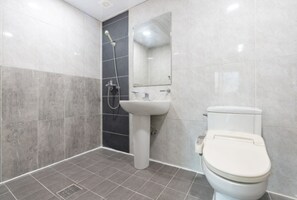 A modern bathroom with a toilet, sink, and shower. - Gyeongju Woorinuri Pension (Gyeongju)
