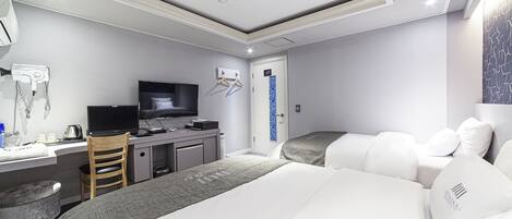 A modern hotel room with a bed, desk, and TV.