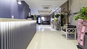 A modern reception area with a reception desk, seating area, and decorative plants. - Business Hotel Duu (Gwangju)