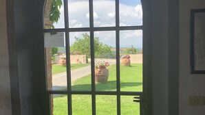 Une vue à travers une fenêtre ornée d’une arche en briques et d’un motif quadrillé.
