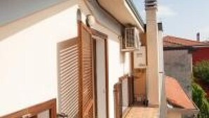 A narrow corridor with a wooden door and a white wall.