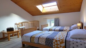 Ein Schlafzimmer mit zwei Betten, einem Holztisch und einem Stuhl.