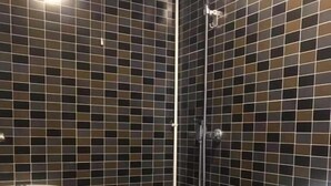 A bathroom with a toilet, a shower, and a sink.