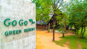 A sign for GoGo Green Resort with a dirt path leading to a building surrounded by trees. - Go Go Green Resort (Habarana)