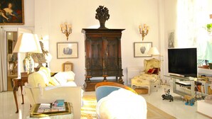 A living room with a large wooden cabinet, two armchairs, a sofa, a television, and a bookshelf. - 4 ROOMS IN THE PALACE OF THE HISTORIC CITY (Cannes)