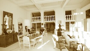 A spacious living room with a high ceiling, a dining area with a marble table, and a balcony with a railing. - 4 ROOMS IN THE PALACE OF THE HISTORIC CITY (Cannes)