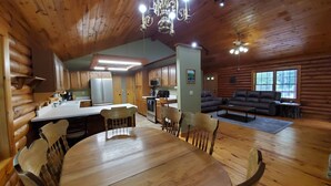L'intérieur d'une cabane en rondins comprend un coin repas, une cuisine et un salon.
