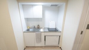 A compact kitchenette with a sink, a small refrigerator, and a microwave.