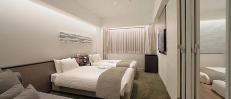 Una habitación de hotel moderna con una cama grande, un sofá, un escritorio y un televisor.