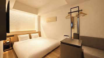 Una habitación de hotel moderna con una cama grande, un escritorio, una silla, un televisor y una ventana con persianas.