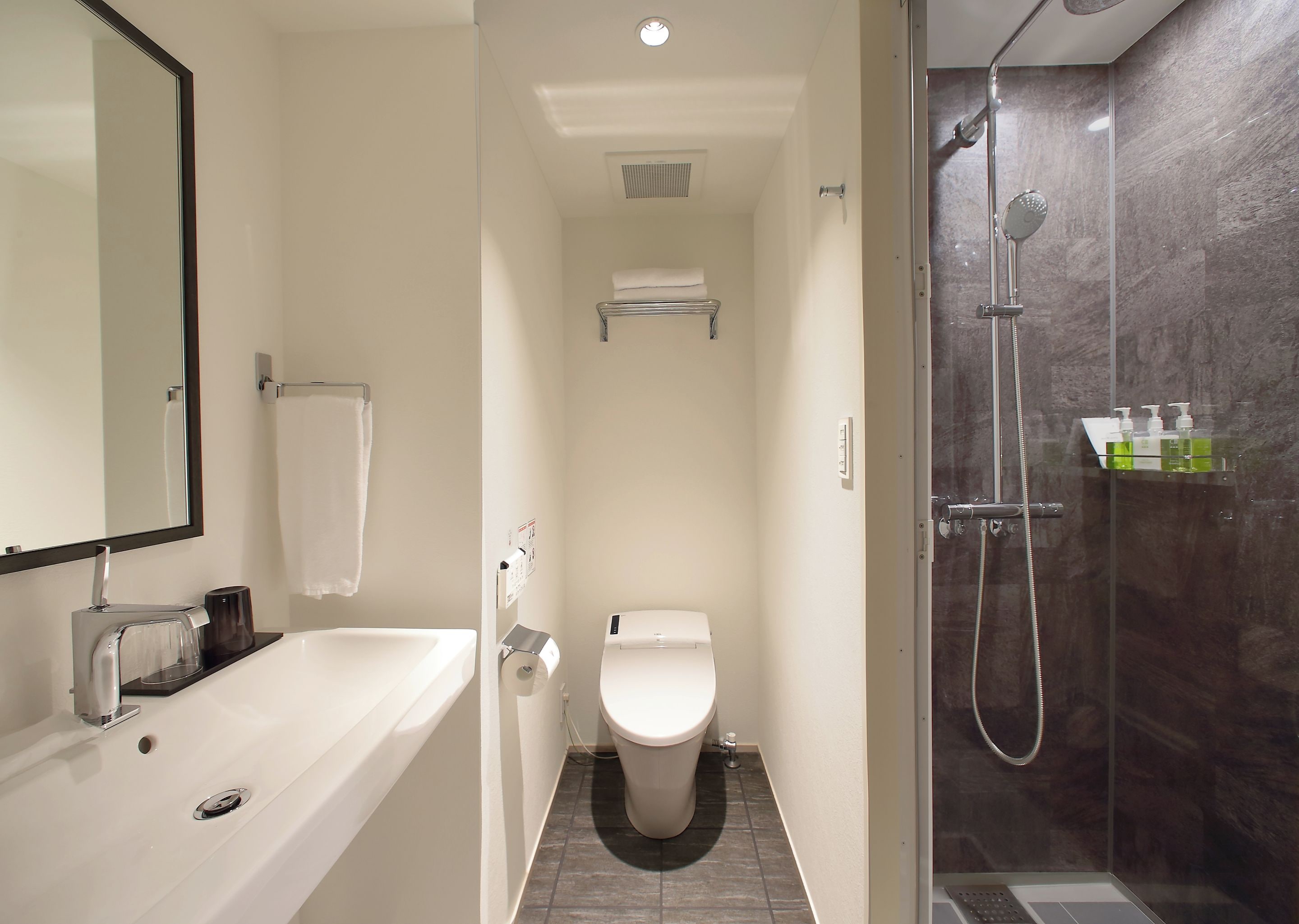 Een moderne badkamer met bad, toilet en douche.