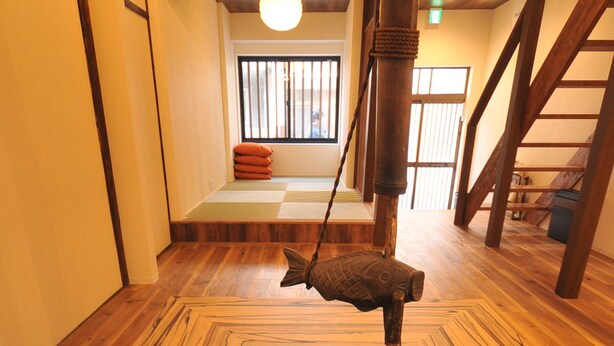 Un plancher en bois avec une découpe carrée au centre et un objet suspendu.