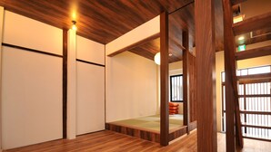 Une pièce dotée d’un plancher en bois, d’une petite estrade en bois et d’une porte coulissante traditionnelle.