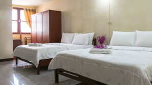 A hotel room with two beds, a wardrobe, and a window with curtains.