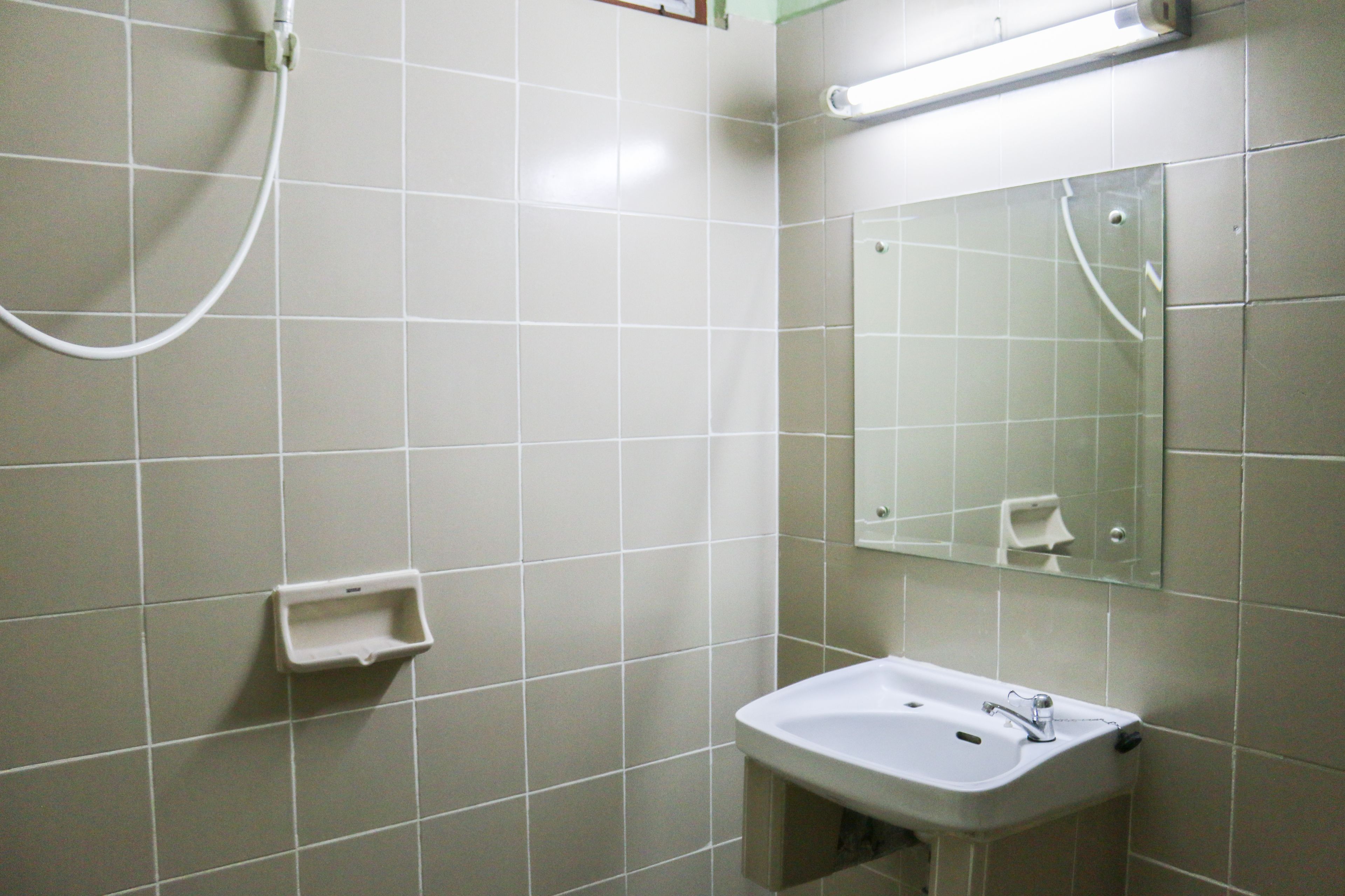 A bathroom with a sink, mirror, and shower.