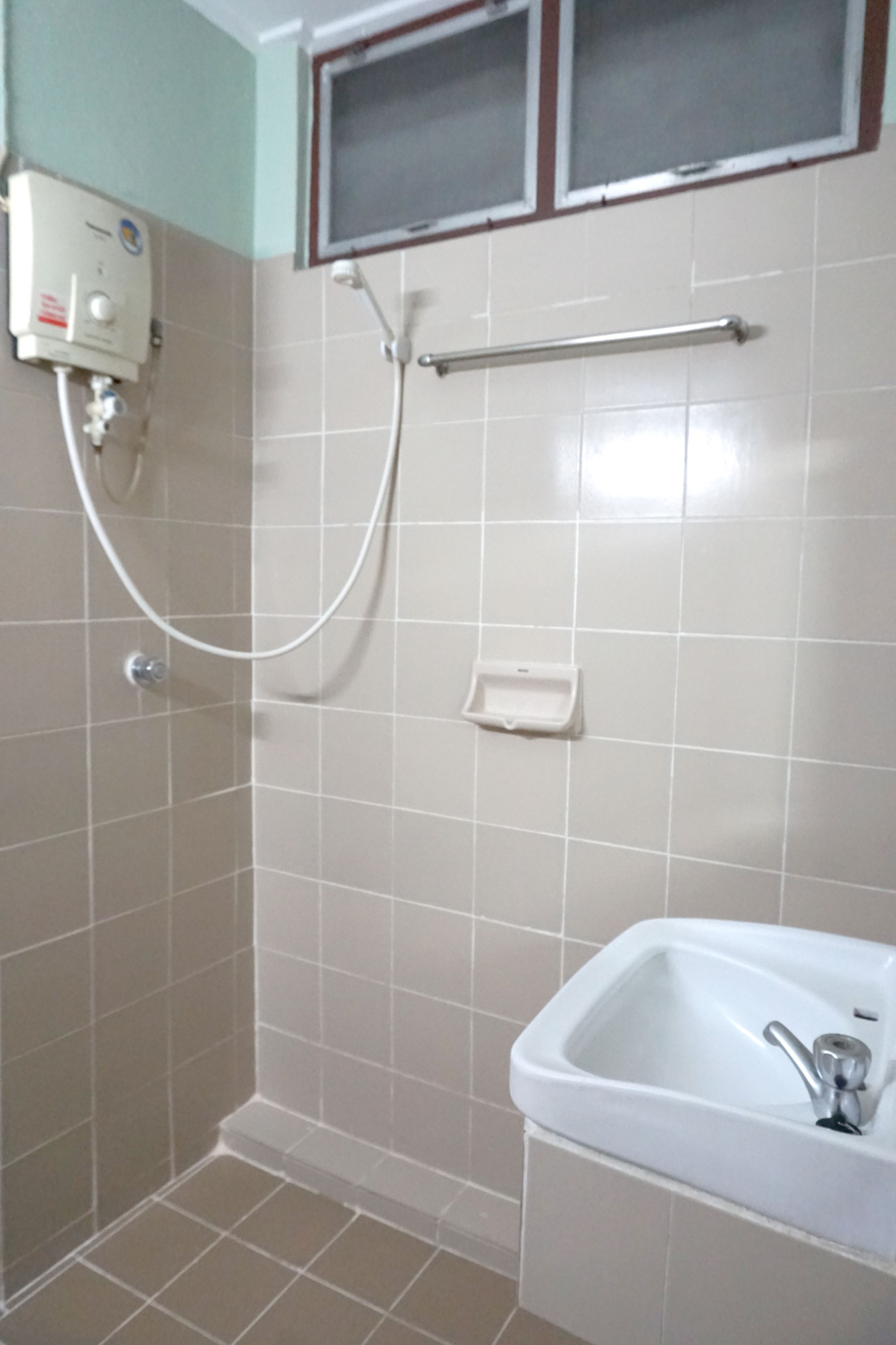 A bathroom with a shower, a sink, and a hand dryer.